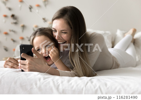 Woman and daughter laughing while watching funny videos on internet Woman and daughter laughing while watching funny videos on internet 116281490