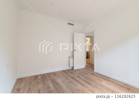 The room is modern with white walls and wooden flooring, creating a bright and clean space 116282625