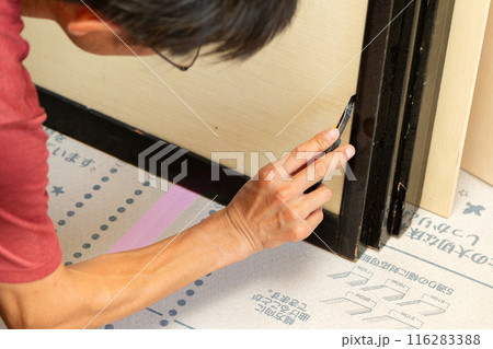 住宅のクロスを張り替える職人 116283388