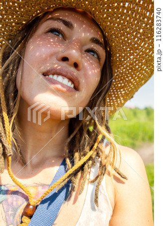 Smiling woman in straw hat. 116283740