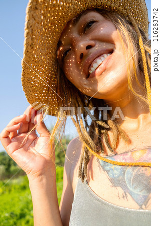 Smiling woman in straw hat. 116283742
