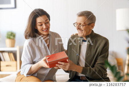 woman congratulating father and giving  him a gift 116283757