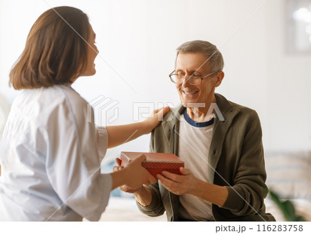 woman congratulating father and giving  him a gift 116283758