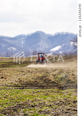 帯広市八千代公共育成牧場で働くトラクター（北海道帯広市） 116284249