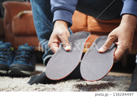 men hand putting Orthopedic insoles in shoes men hand putting Orthopedic insoles in shoes 116284497
