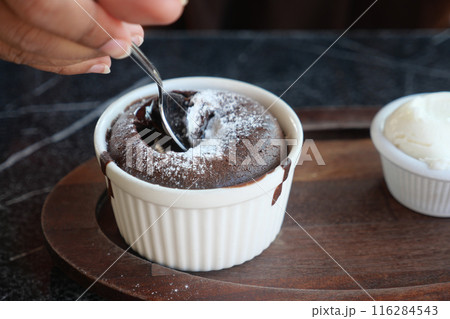 Delicious Chocolate Lava Cake with Powdered Sugar and Whipped Cream on Wooden Plate Delicious Chocolate Lava Cake with Powdered Sugar and Whipped Cream on Wooden Plate 116284543
