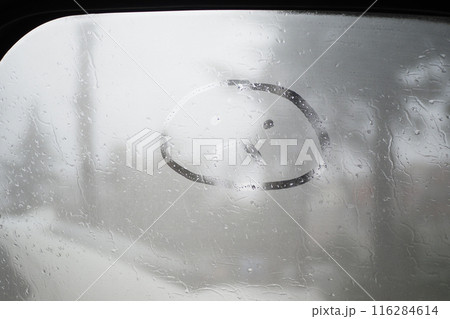 sad face drawn natural water drops glass window background. 116284614