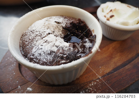 Delicious Chocolate Lava Cake with Powdered Sugar and Whipped Cream on Wooden Plate 116284703