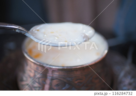 Enjoy a Delicious Bowl of Soup topped with Fresh Parsley in a Stylish Black Ceramic Bowl 116284732