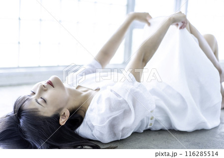 寝転ぶ白ワンピースの若い女性 116285514