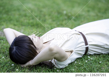 新緑の芝生で寝転ぶ女性 116287201
