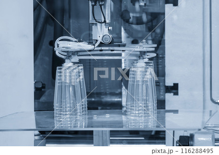 The plastic drinking glass part gripping by vacuum robotic system from injection machine. The plastic drinking glass part gripping by vacuum robotic system from injection machine. 116288495