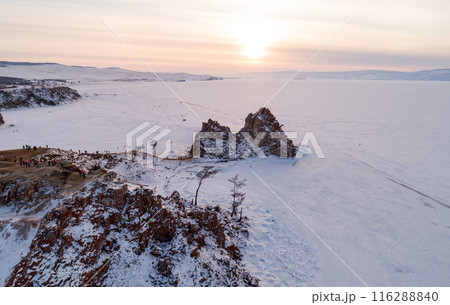 Aerial shot of a Shamanka rock on Olkhon island at sunset. Winter landscape. Popular touristic destination. Natural landmark. Panoramic view 116288840