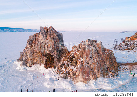 Aerial shot of a Shamanka rock on Olkhon island at sunset. Winter landscape. Popular touristic destination. Natural landmark. Panoramic view 116288841