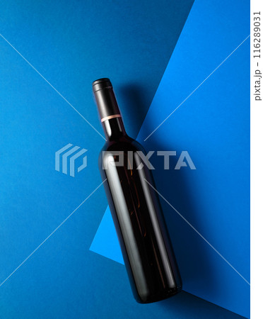 Bottle of red wine on a blue background. 116289031
