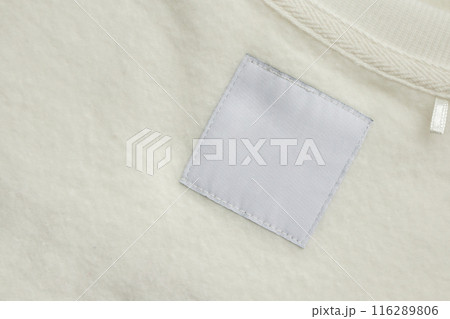 Blank white laundry care clothes label on fabric texture background 116289806