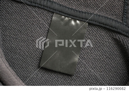 Blank black laundry care clothes label on black fabric texture background 116290082