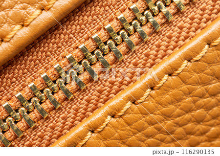 close up of zipper on brown leather bag 116290135