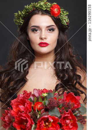 Beautiful woman with a wreath on her head from real flowers on black background 116290158