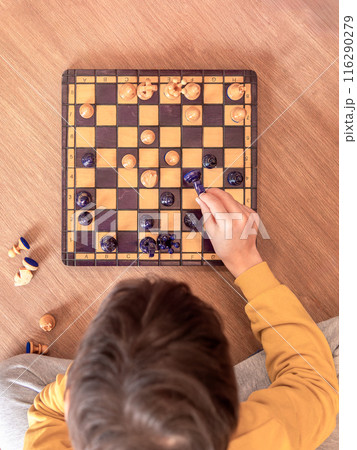 A boy deeply focused on playing chess. 116290279