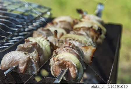 Preparation on fire of pieces of meat strung on a skewer. Pieces of meat on skewers are roasted on the grill 116291059