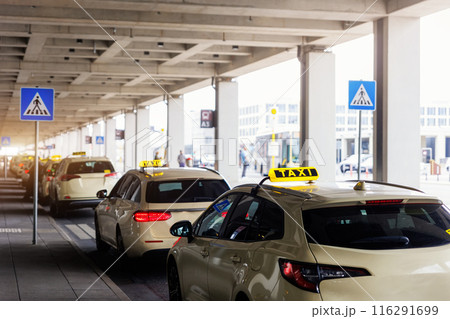 Taxi car Queue yellow taxi symbol  on roof stand waiting at parking of airport terminal or railway station Under Concrete Structure Transportation Hub. Urban street transportation comfort service 116291699