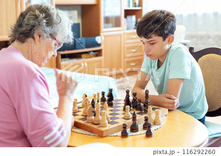 Grandmother and grandson playing chess at home Grandmother and grandson playing chess at home 116292260