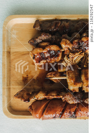 Mala skewers served on the wooden plate. 116292547