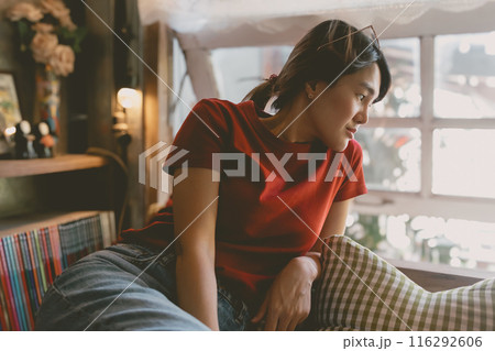 Sleepy woman in red t-shirt resting in the living room near the windows. Sleepy woman in red t-shirt resting in the living room near the windows. 116292606