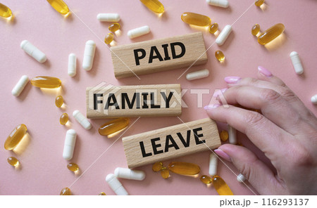Paid Family Leave symbol. Concept words Paid Family Leave on wooden blocks. Beautiful pink background with pills. Doctor hand. Healthcare and Paid Family Leave concept. Copy space. 116293137
