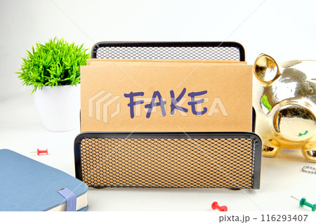 Fake news and digital communication concept. FAKE written on a postal envelope in a stand on a white background 116293407