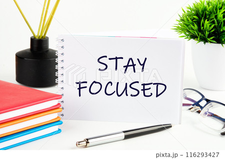 STAY FOCUSED text in a notebook on a light background in a composition with business accessories 116293427