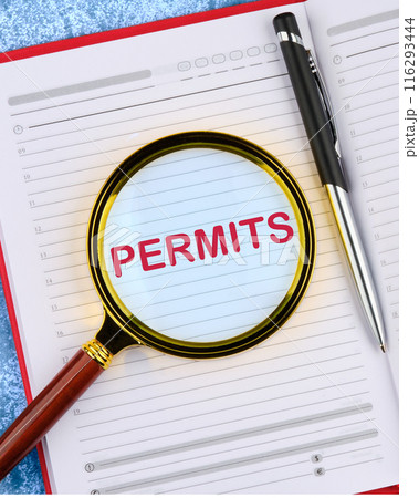 Business concept. The text PERMITS. viewed through a magnifying glass in a business notebook Business concept. The text PERMITS. viewed through a magnifying glass in a business notebook 116293444