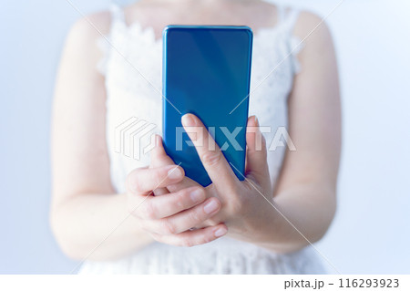 Close-up of female hands holding a cell phone. Using technology. Close-up of female hands holding a cell phone. Using technology. 116293923