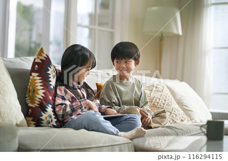 two cute little asian kids using digital tablet at home 116294115