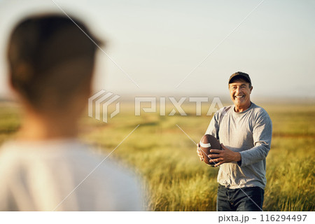 Kid, man and football with teaching in nature for outdoor adventure, happiness and child development. Smile, dad and sports with son on grass field for exercise, practice and bonding on fathers day 116294497