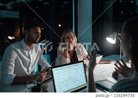 Employee, teamwork and laptop in office at night with documents for deadline or overtime as accountant. People, partnership and feedback or explain for financial reviews, records and graph on screen 116294738