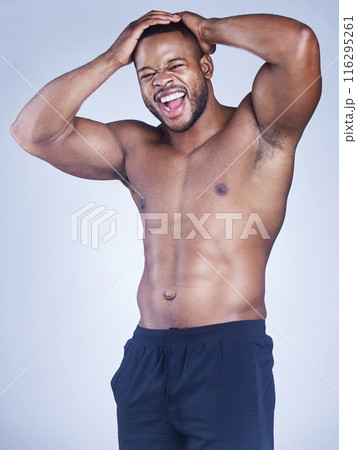 Black man, portrait and shirtless muscle in studio, strong core and six pack on blue background. Male person, confidence and athlete for power or healthy body, bodybuilder and topless for fitness 116295261