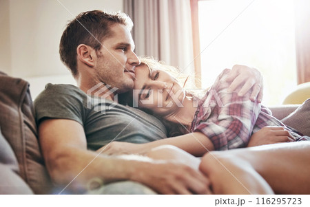 Couple, relax and home in lounge, love and cozy in marriage, embrace and peace in break and morning. House, man and woman on sofa, together and rest in living room, bonding and smile for relationship 116295723