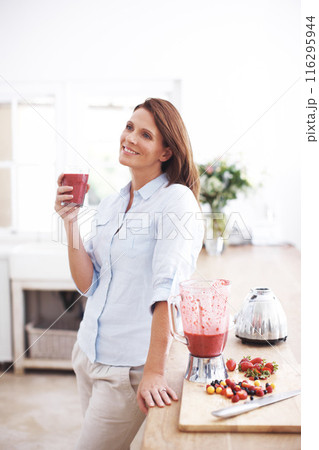 Woman, drinking and glass in kitchen for smoothie or milkshake, handmade and fruit recipe for breakfast detox diet. Girl, strawberry and home for meal alternative, vitamin boost and natural protein 116295944