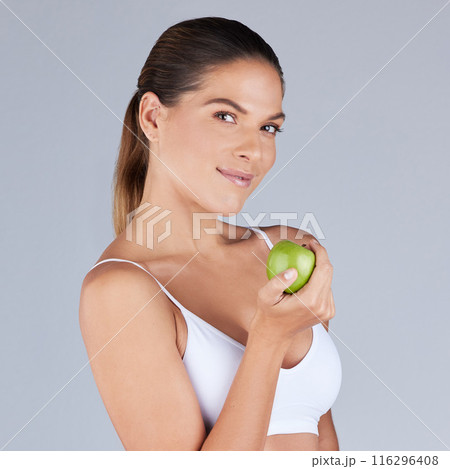 Portrait, woman and apple smiling for healthy diet, fitness and nutrition in grey studio background. Wellness, female person and fruit happy for organic meal, snack or vegan eating with vitamins 116296408