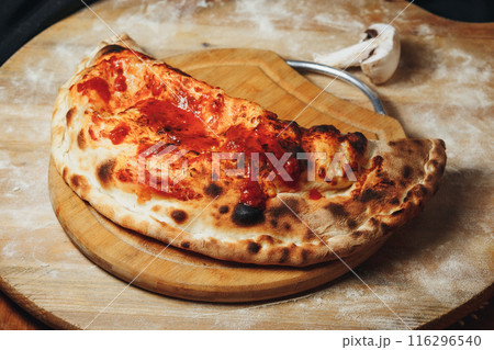 Rustic Calzone on a Wooden Board 116296540