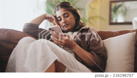 Living room, phone and reading in home, girl and thinking in morning, digital and online on couch. House, social media and lounge with web, calm and texting in apartment, streaming or subscription 116296787