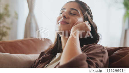 Sleeping, woman and relax on sofa house listening to music with wireless earphones, radio and podcast in living room. Smile, female person and streaming audio, connection and subscription for peace 116296914