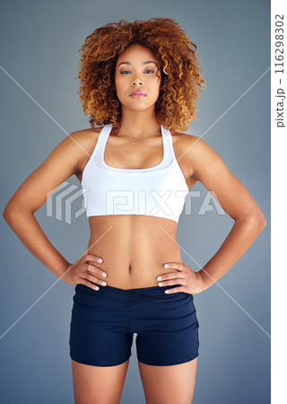 Woman, studio and confident for wellness in portrait, sportswear and training on gray background. Person, body and athlete for results of workout or exercise, serious and proud of transformation 116298302