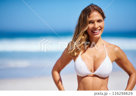 Portrait, woman and relax in bikini on beach for adventure, holiday or sunshine at tropical resort in Maldives. Confident, female person and travel on vacation, peace or blue sky by ocean waves 116298629