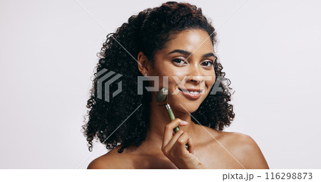 Jade roller, portrait and woman with cosmetics, wellness and grooming routine on grey studio background. Face, person and model with tool, self care and massage with skincare, dermatology and beauty 116298873