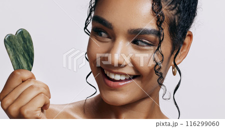 Skincare, gua sha and woman with jade crystal for wellness, dermatology and luxury spa. Body, cosmetics and lady glow with natural stone, anti aging or facial treatment on white studio background 116299060