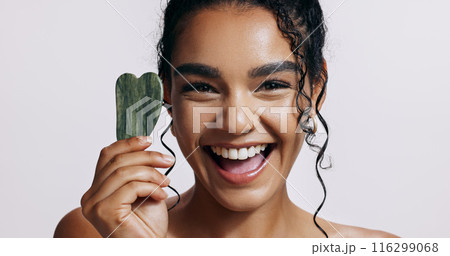 Smile, portrait and woman with gua sha for skincare, dermatology and luxury spa. Face, cosmetics and lady glow with jade crystal, anti aging or natural stone treatment on white studio background Smile, portrait and woman with gua sha for skincare, dermatology and luxury spa. Face, cosmetics and lady glow with jade crystal, anti aging or natural stone treatment on white studio background 116299068