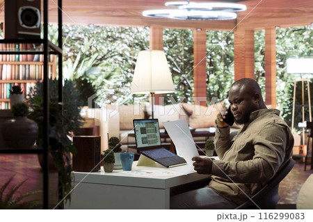 Business owner having a chat on phone call with the shareholders, communicating the current enterprise profit situation from his home office. Entrepreneur asking for new funding. 116299083